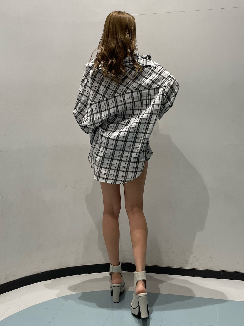 ホワイト系のキャミソール、ブルー系のデニムパンツ、ホワイト系のブーツを着用したレディースの春コーディネートの3枚目の写真