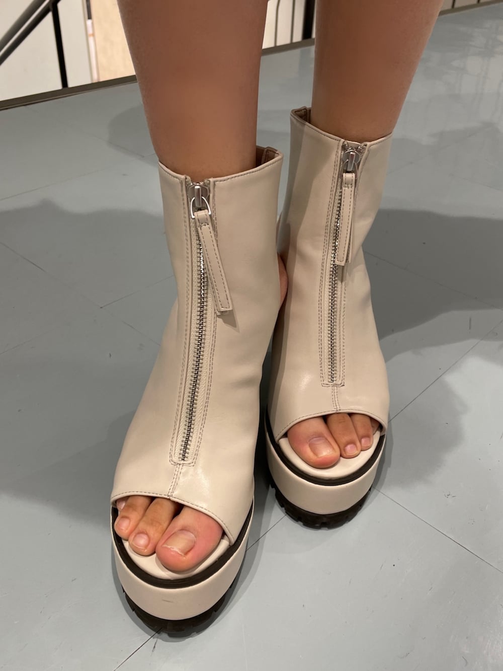 ホワイト系のキャミソール、ブルー系のデニムパンツ、ホワイト系のブーツを着用したレディースの春コーディネートの7枚目の写真