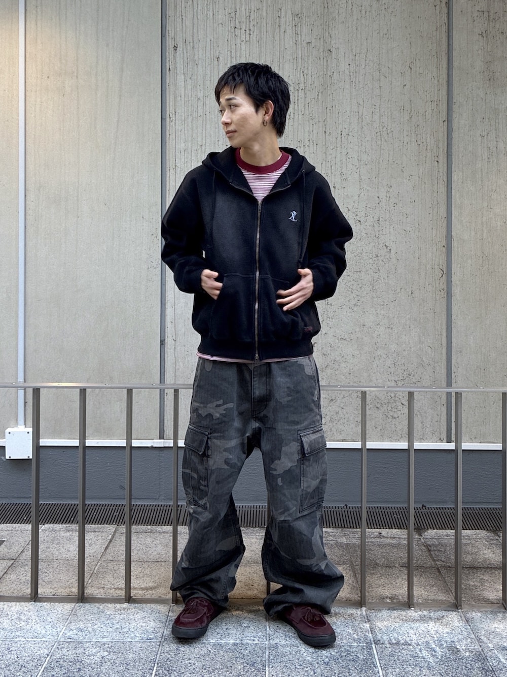 ブラック系のパーカー、レッド系のTシャツ/カットソー、ブラック系のカーゴパンツを着用したメンズの冬コーディネートの2枚目の写真