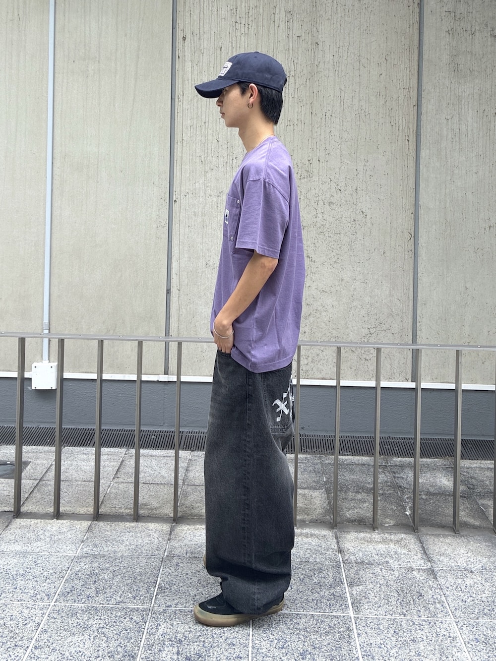 パープル系のTシャツ/カットソー、ブラック系のデニムパンツ、ブルー系のキャップを着用したメンズの夏コーディネートの2枚目の写真