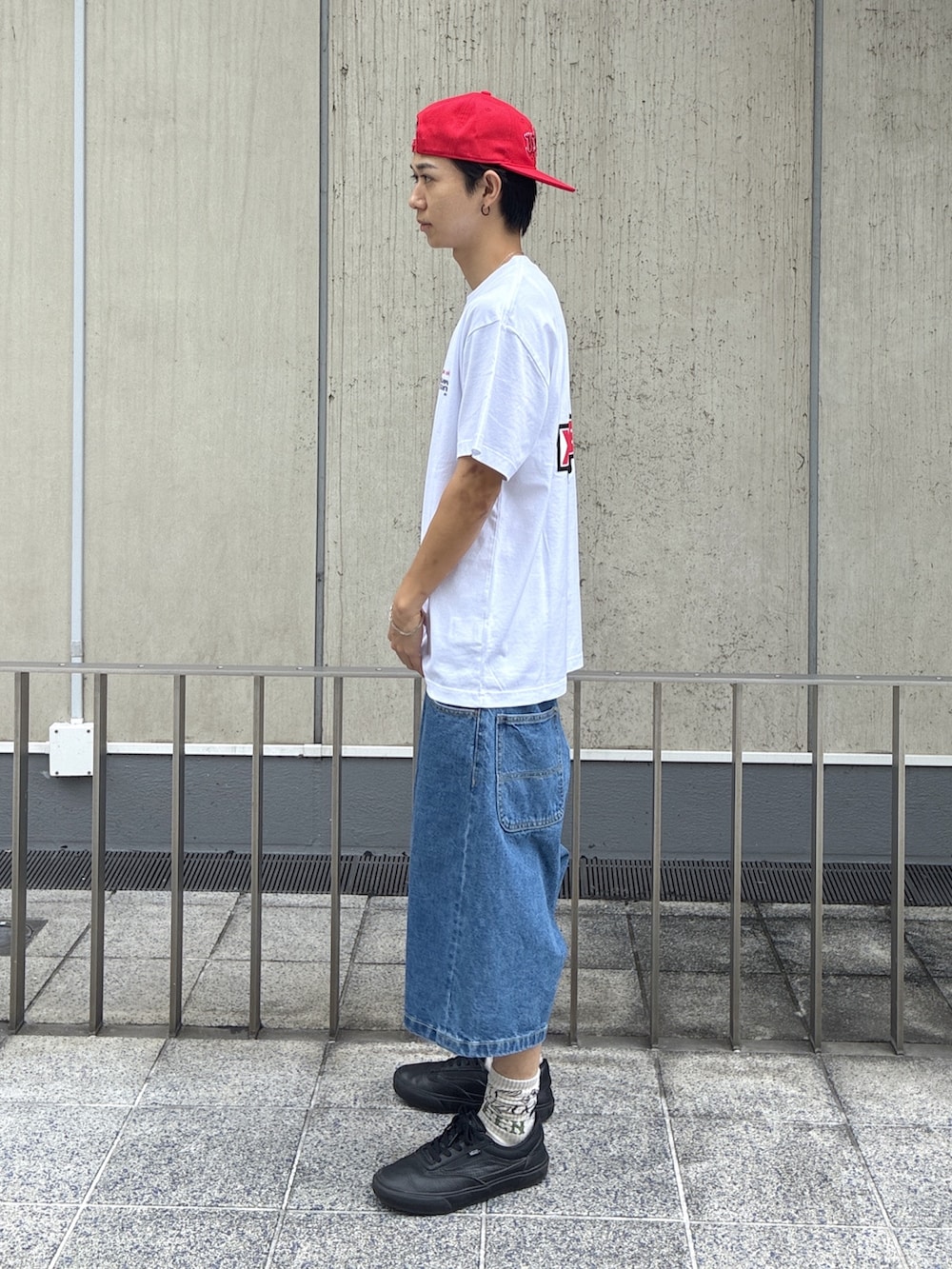ブルー系のその他パンツ、レッド系のキャップを着用したメンズの夏コーディネートの2枚目の写真