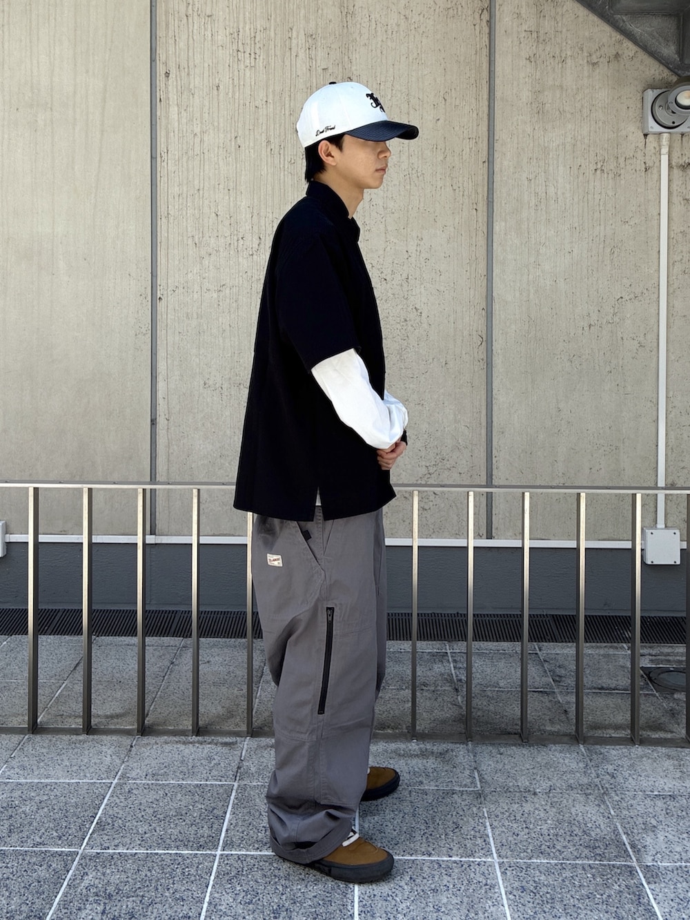 ブラック系のシャツ/ブラウス、グレー系のその他パンツ、ホワイト系のキャップを着用したメンズの春コーディネートの4枚目の写真