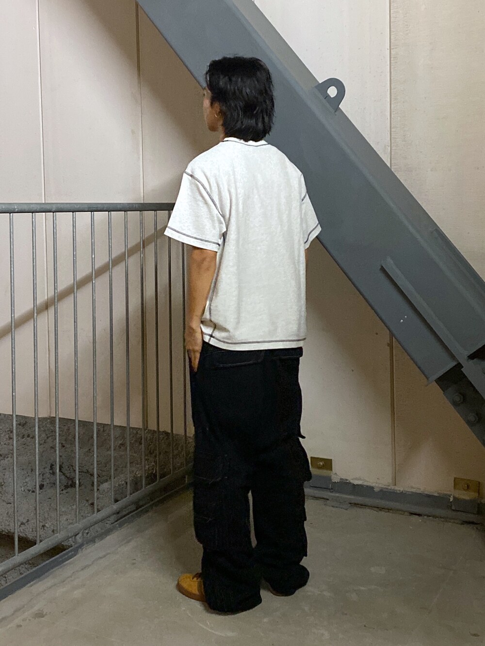 グレー系のTシャツ/カットソー、ブラック系のカーゴパンツを着用したメンズの春コーディネートの2枚目の写真