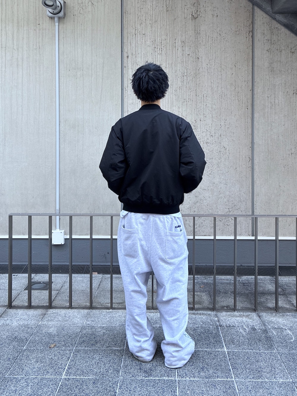 ブラック系のブルゾン、ホワイト系のTシャツ/カットソーを着用したメンズの冬コーディネートの5枚目の写真