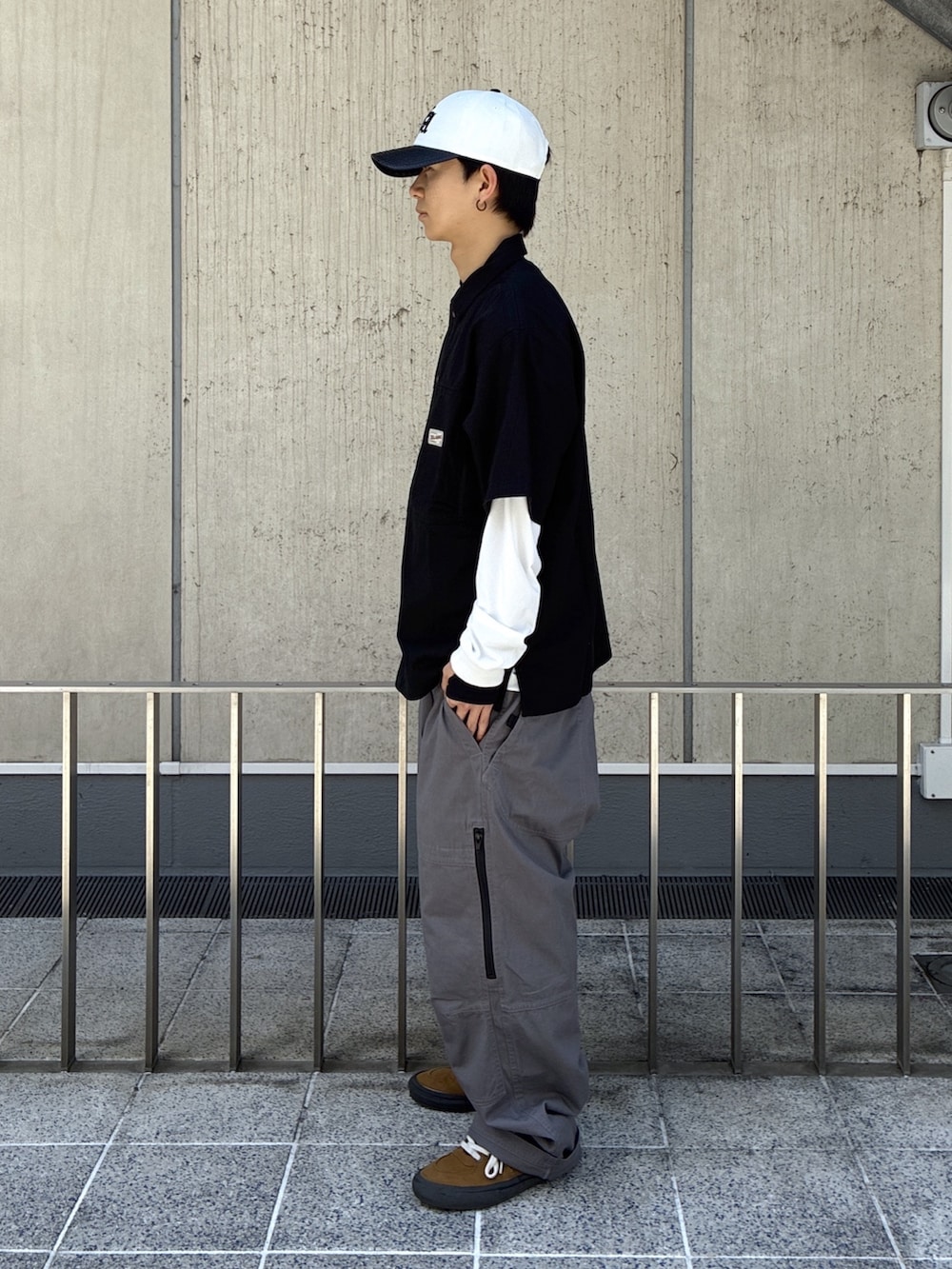 ブラック系のシャツ/ブラウス、グレー系のその他パンツ、ホワイト系のキャップを着用したメンズの春コーディネートの2枚目の写真
