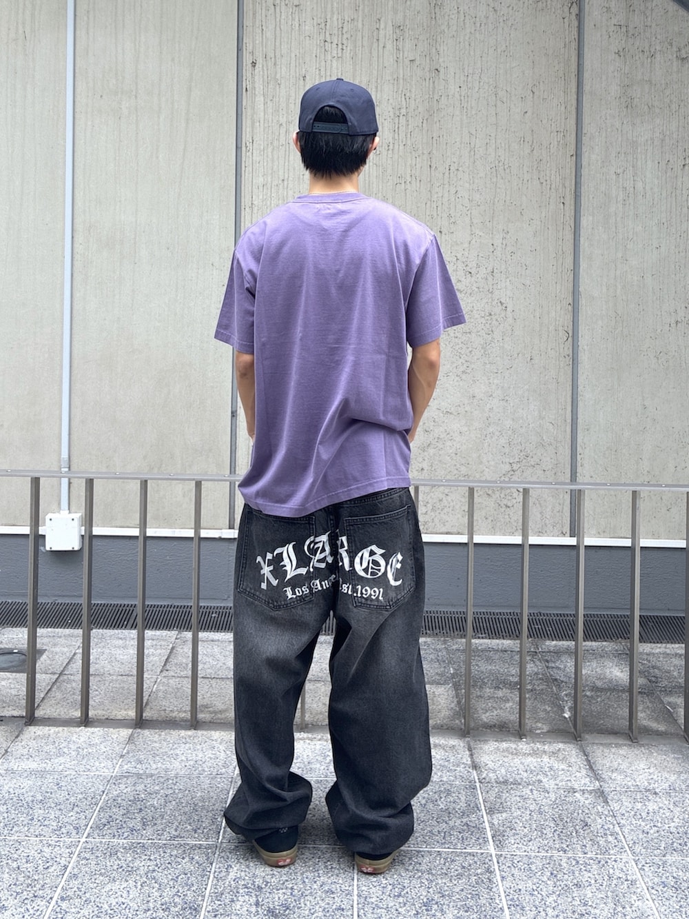 パープル系のTシャツ/カットソー、ブラック系のデニムパンツ、ブルー系のキャップを着用したメンズの夏コーディネートの3枚目の写真
