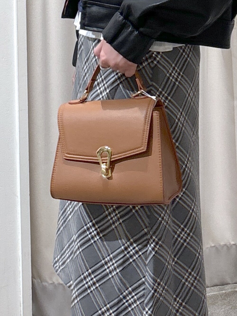 ブラック系のブルゾン、ブルー系のTシャツ/カットソー、ベージュ系のトートバッグを着用したレディースの秋コーディネートの9枚目の写真