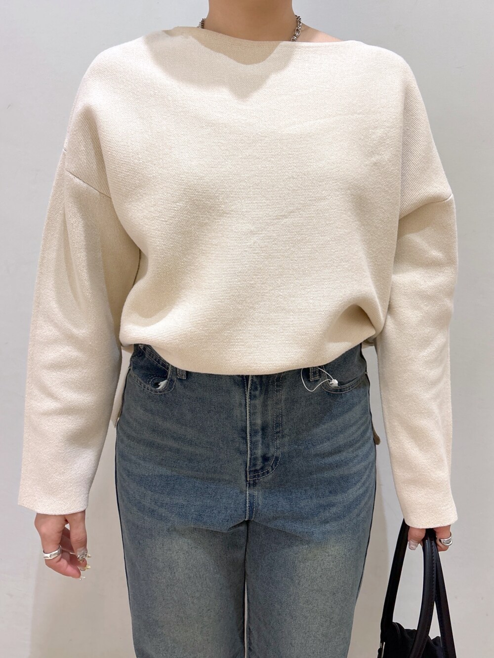 ホワイト系のニット/セーター、ブルー系のデニムパンツ、ブラック系のローファーを着用したレディースの冬コーディネートの5枚目の写真