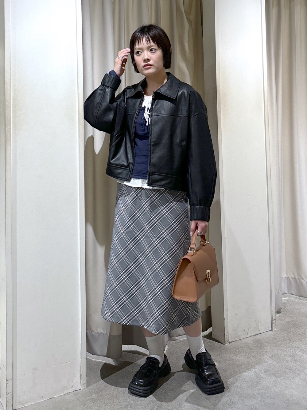 ブラック系のブルゾン、ブルー系のTシャツ/カットソー、ベージュ系のトートバッグを着用したレディースの秋コーディネートの2枚目の写真