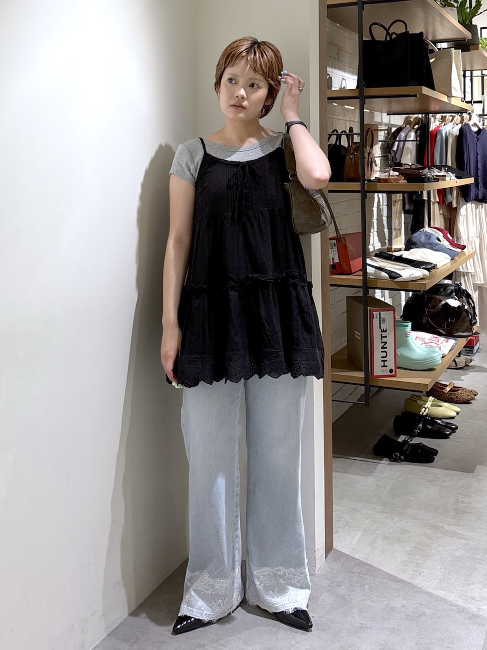 ブラック系のワンピース、グレー系のTシャツ/カットソー、ブルー系のデニムパンツを着用したレディースの夏コーディネートの2枚目の写真