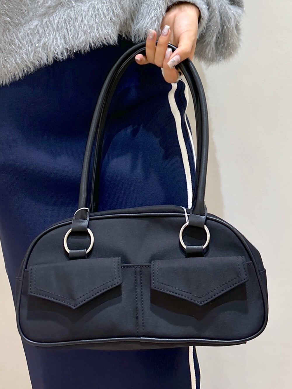 ブルー系のスカート、ブラック系のブーツ、ブラック系のトートバッグを着用したレディースの秋コーディネートの10枚目の写真