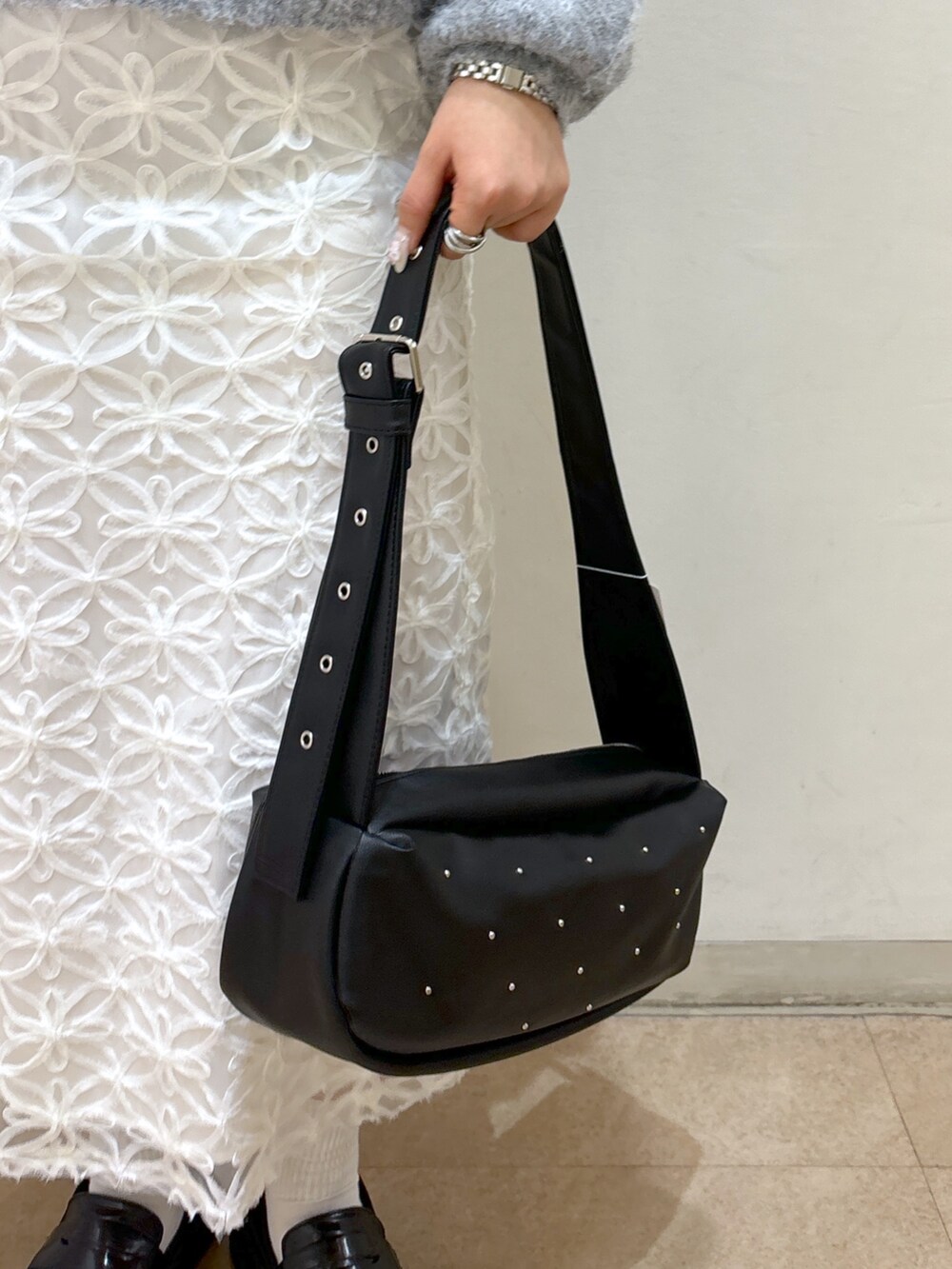 グレー系のニット/セーター、ホワイト系のスカート、ブルー系のショルダーバッグを着用したレディースの冬コーディネートの7枚目の写真