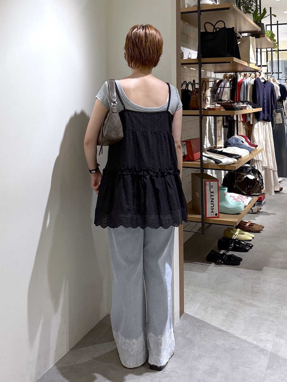 ブラック系のワンピース、グレー系のTシャツ/カットソー、ブルー系のデニムパンツを着用したレディースの夏コーディネートの3枚目の写真