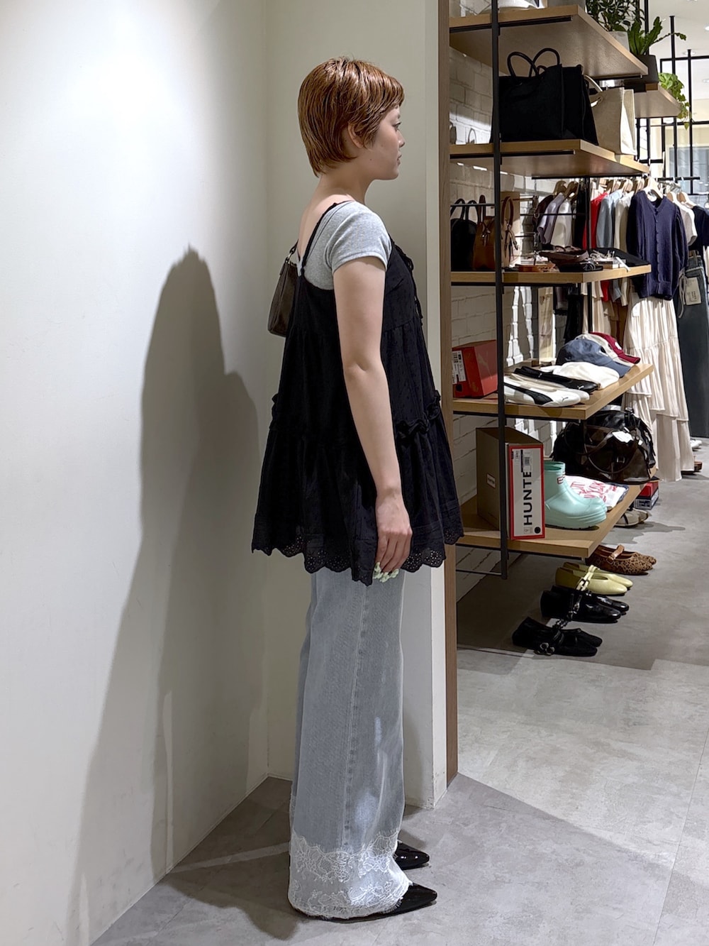 ブラック系のワンピース、グレー系のTシャツ/カットソー、ブルー系のデニムパンツを着用したレディースの夏コーディネートの4枚目の写真