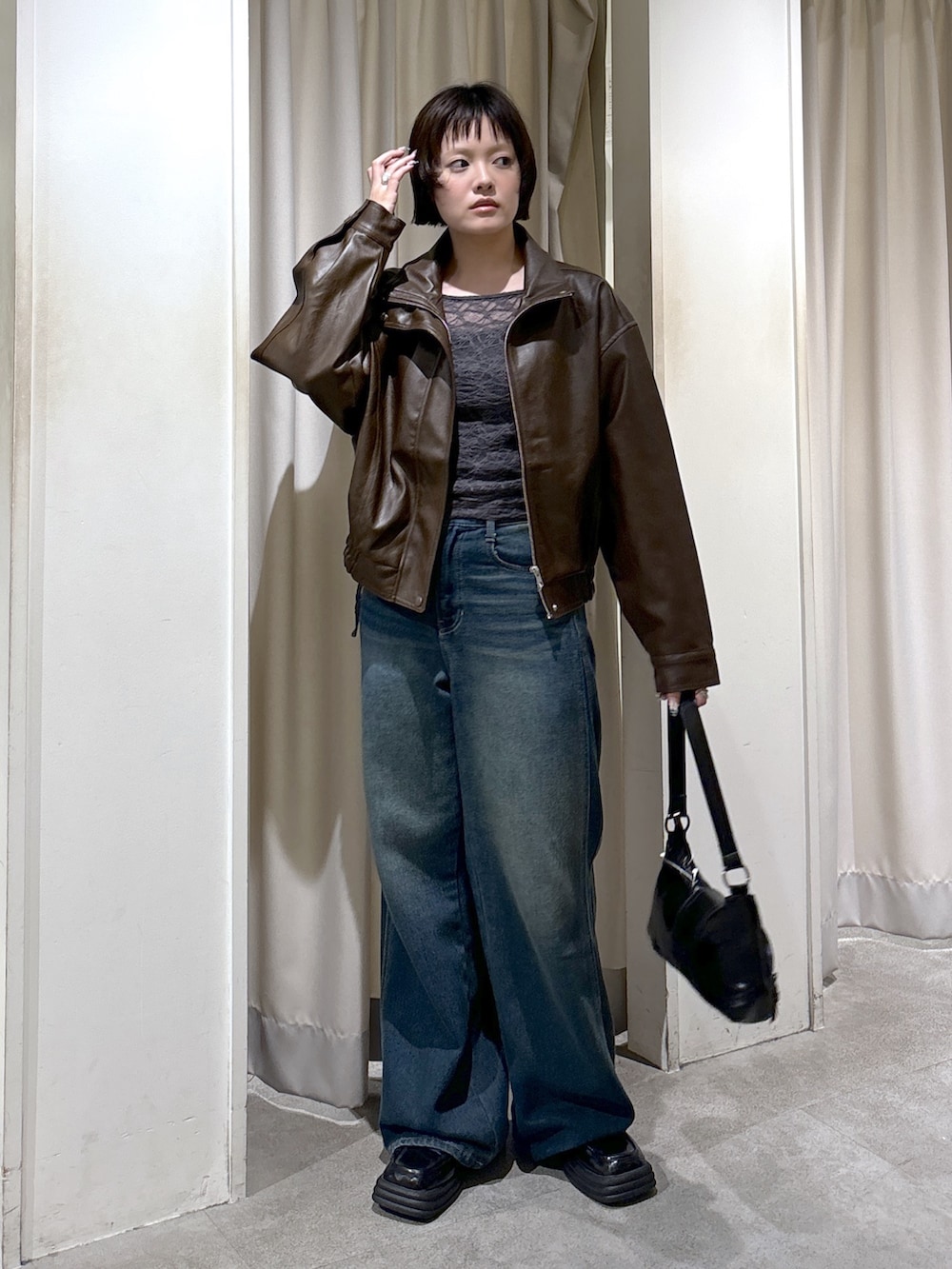 ブラウン系のブルゾン、グレー系のTシャツ/カットソー、ブルー系のデニムパンツを着用したレディースの秋コーディネートの2枚目の写真