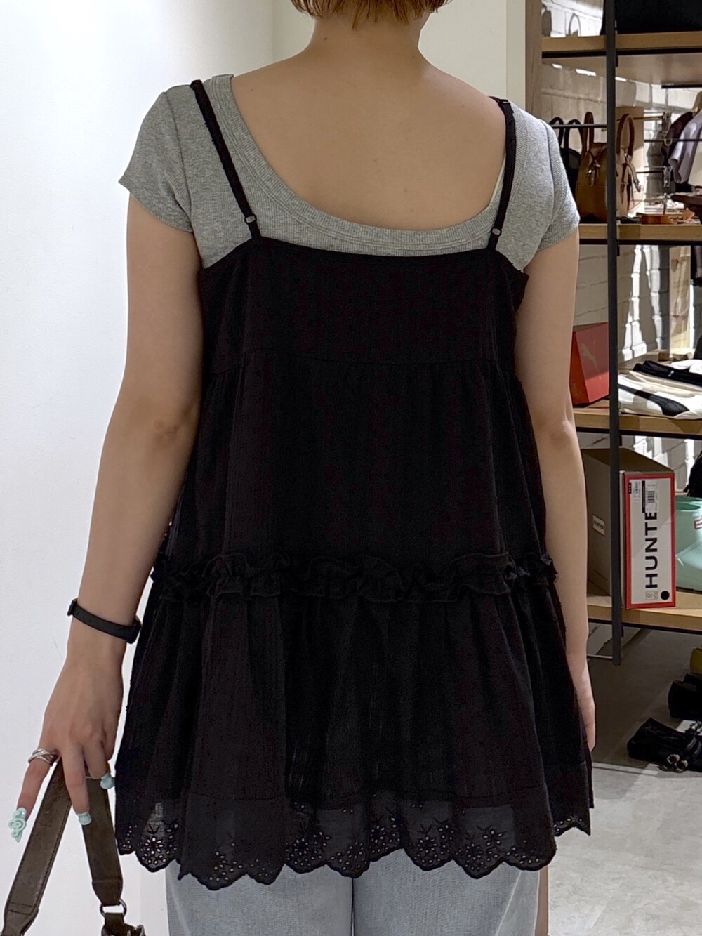 ブラック系のワンピース、グレー系のTシャツ/カットソー、ブルー系のデニムパンツを着用したレディースの夏コーディネートの6枚目の写真