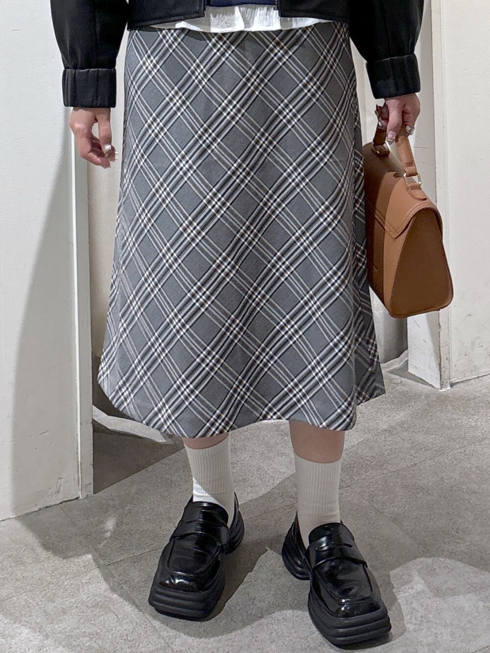 ブラック系のブルゾン、ブルー系のTシャツ/カットソー、ベージュ系のトートバッグを着用したレディースの秋コーディネートの8枚目の写真