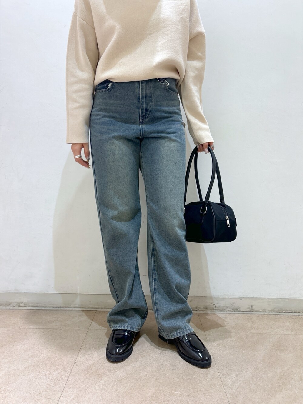 ホワイト系のニット/セーター、ブルー系のデニムパンツ、ブラック系のローファーを着用したレディースの冬コーディネートの6枚目の写真