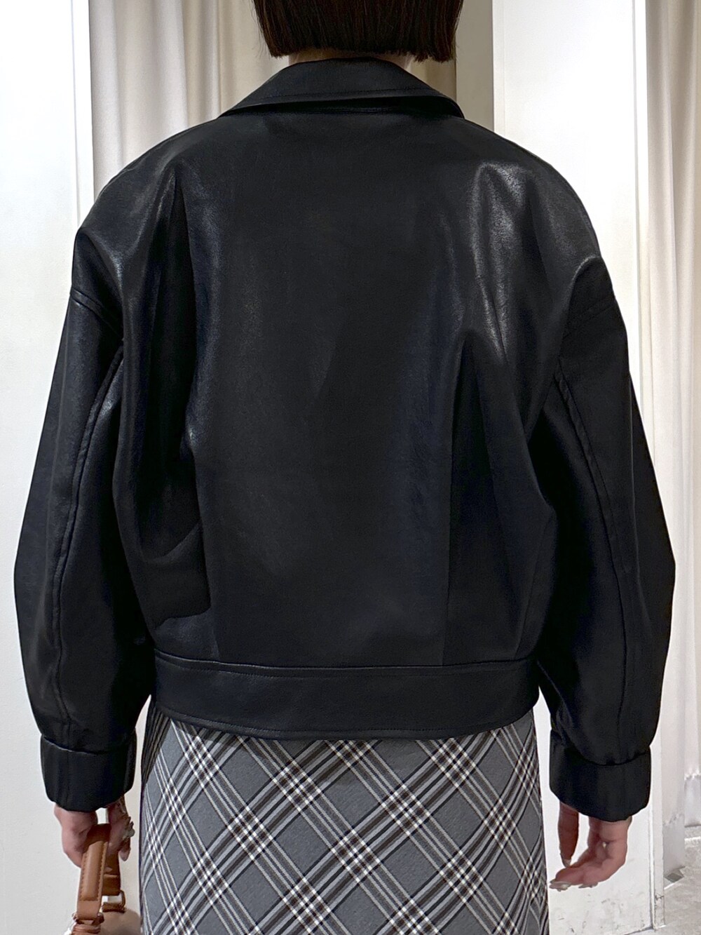 ブラック系のブルゾン、ブルー系のTシャツ/カットソー、ベージュ系のトートバッグを着用したレディースの秋コーディネートの6枚目の写真