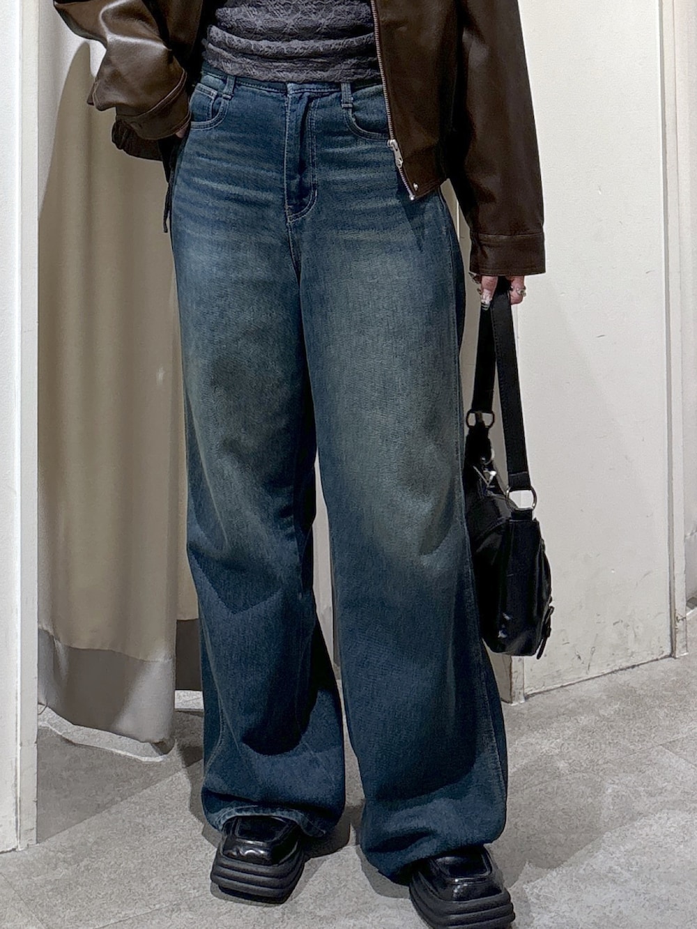 ブラウン系のブルゾン、グレー系のTシャツ/カットソー、ブルー系のデニムパンツを着用したレディースの秋コーディネートの7枚目の写真