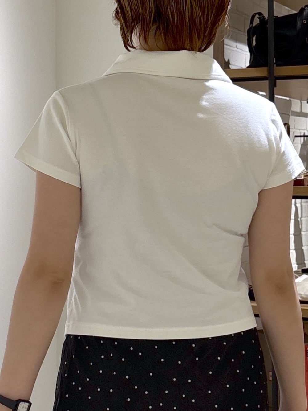 ホワイト系のTシャツ/カットソー、ブラック系のスカート、ブラウン系のショルダーバッグを着用したレディースの夏コーディネートの6枚目の写真