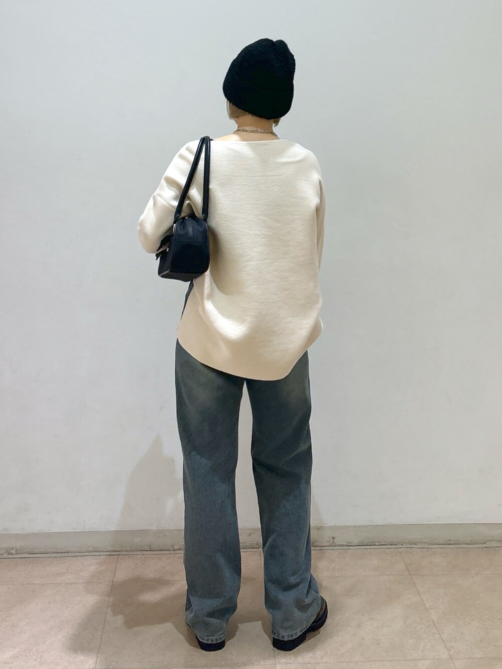 ホワイト系のニット/セーター、ブルー系のデニムパンツ、ブラック系のローファーを着用したレディースの冬コーディネートの3枚目の写真