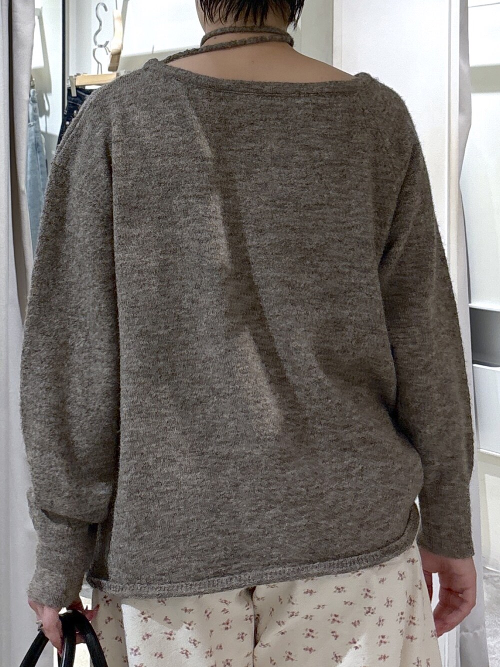 ブラウン系のニット/セーター、ホワイト系のデニムパンツ、ブラック系のハンドバッグを着用したレディースの冬コーディネートの5枚目の写真
