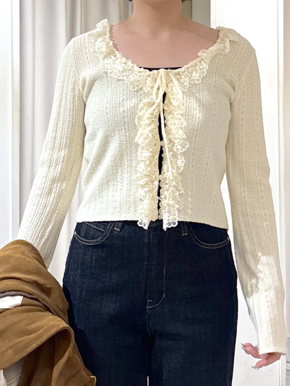 ブラウン系のブルゾン、ホワイト系のニット/セーター、ブルー系のデニムパンツを着用したレディースの秋コーディネートの8枚目の写真