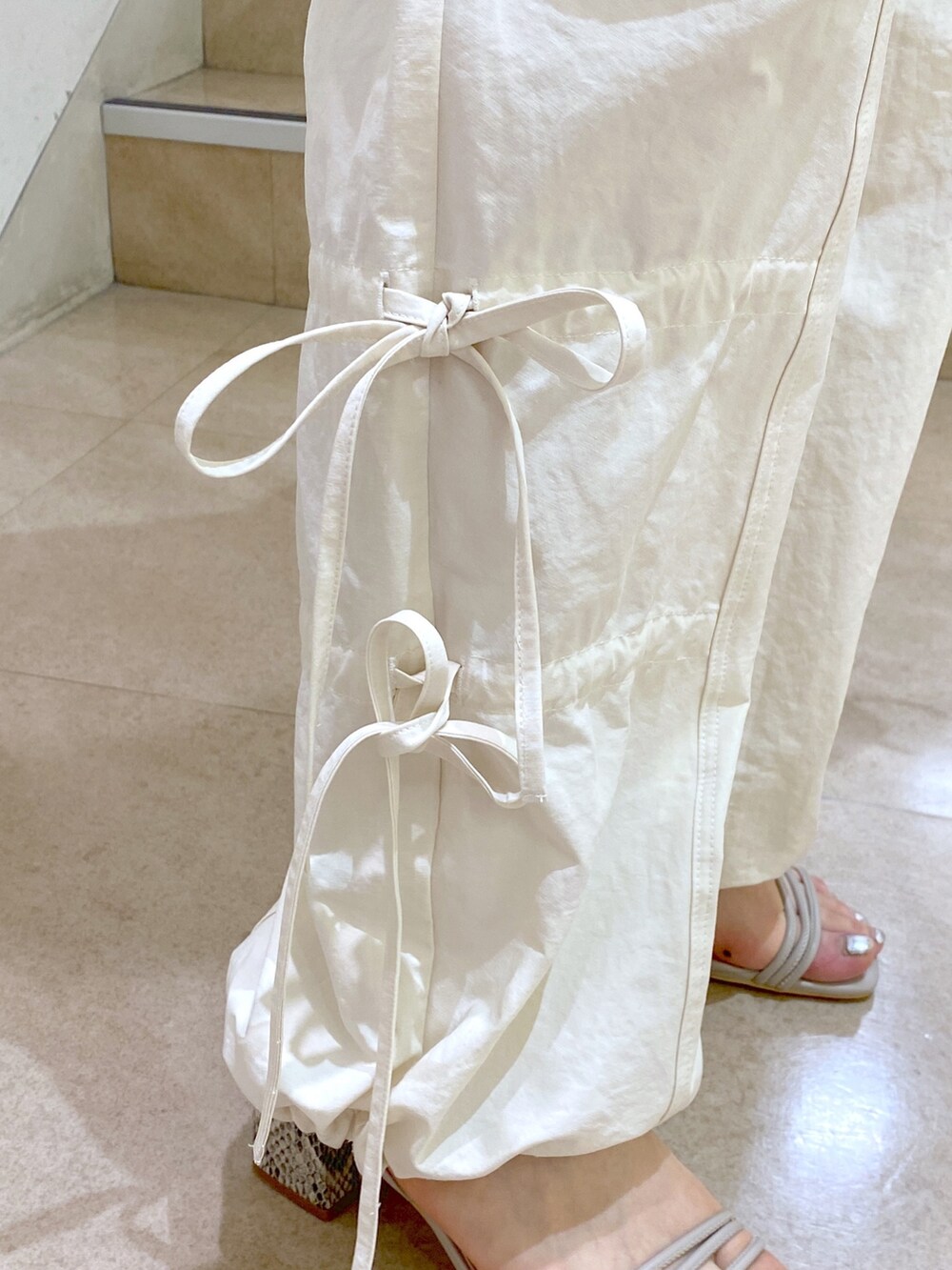 グレー系のノーカラージャケット、ホワイト系のカーゴパンツ、ブラック系のショルダーバッグを着用したレディースの春コーディネートの8枚目の写真