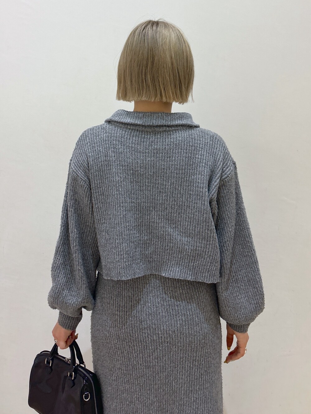 グレー系のワンピース、ホワイト系のダウンジャケット/コート、ブラック系のブーツを着用したレディースの冬コーディネートの8枚目の写真