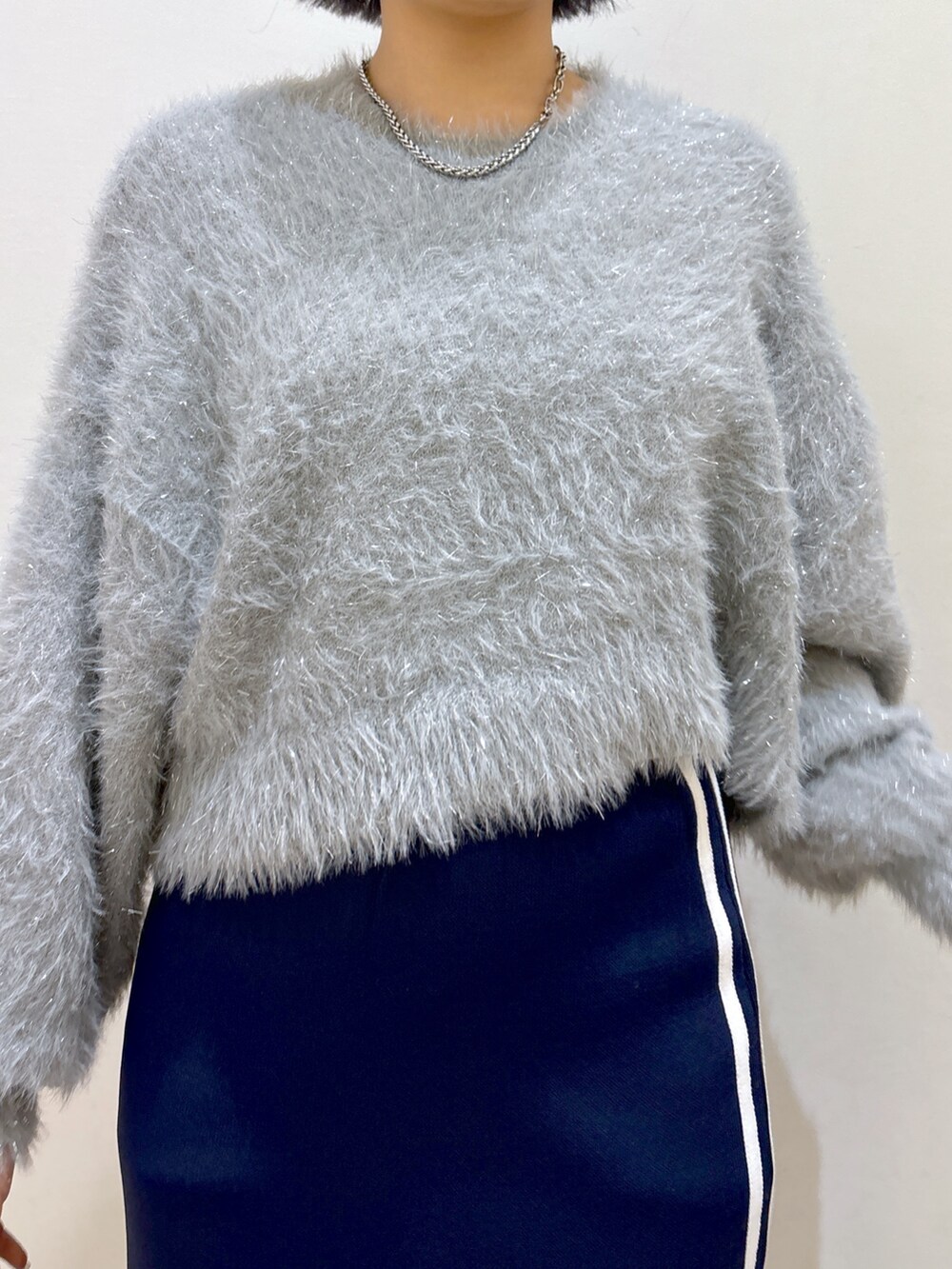 ブルー系のスカート、ブラック系のブーツ、ブラック系のトートバッグを着用したレディースの秋コーディネートの7枚目の写真