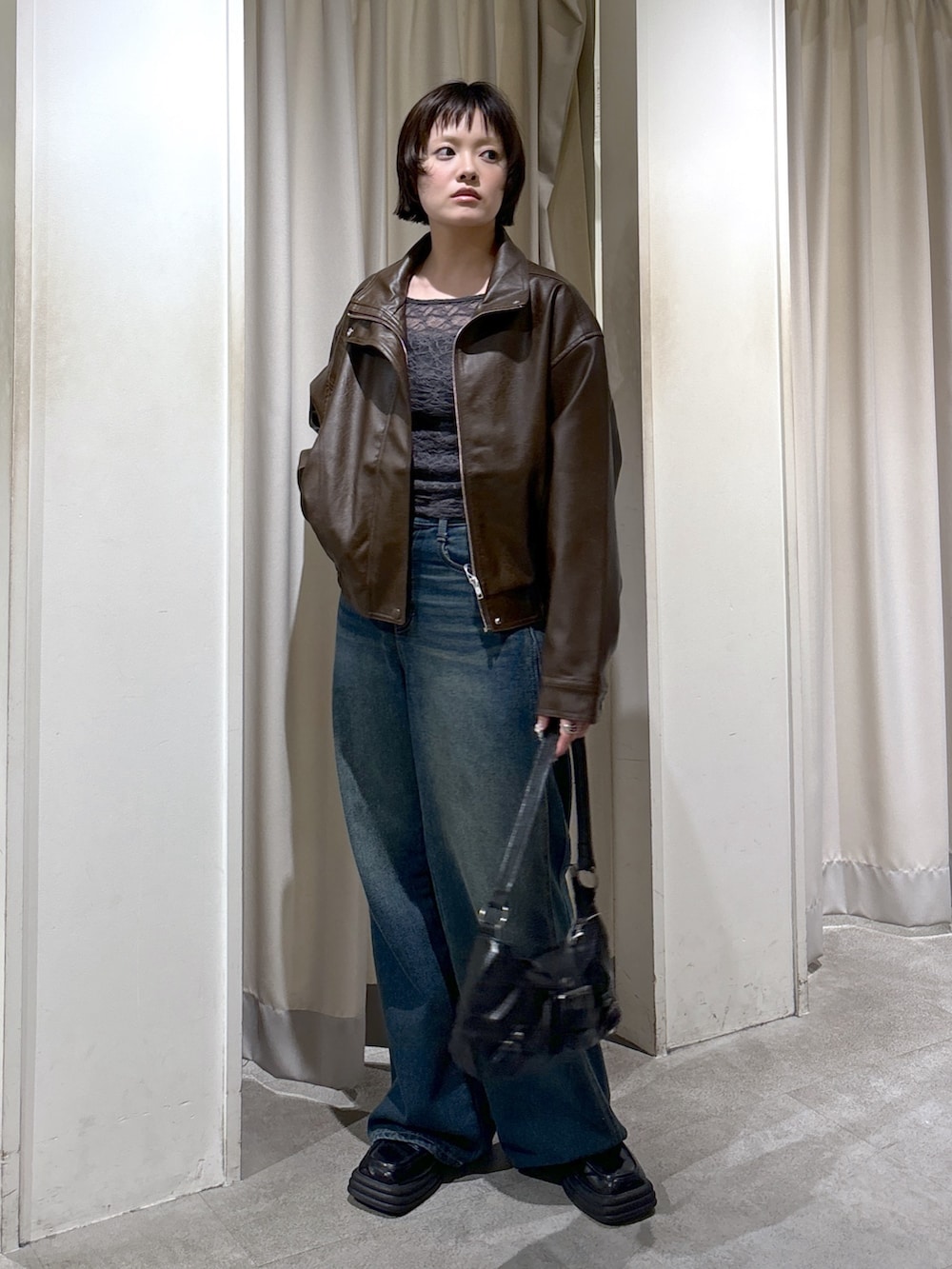 ブラウン系のブルゾン、グレー系のTシャツ/カットソー、ブルー系のデニムパンツを着用したレディースの秋コーディネートの3枚目の写真