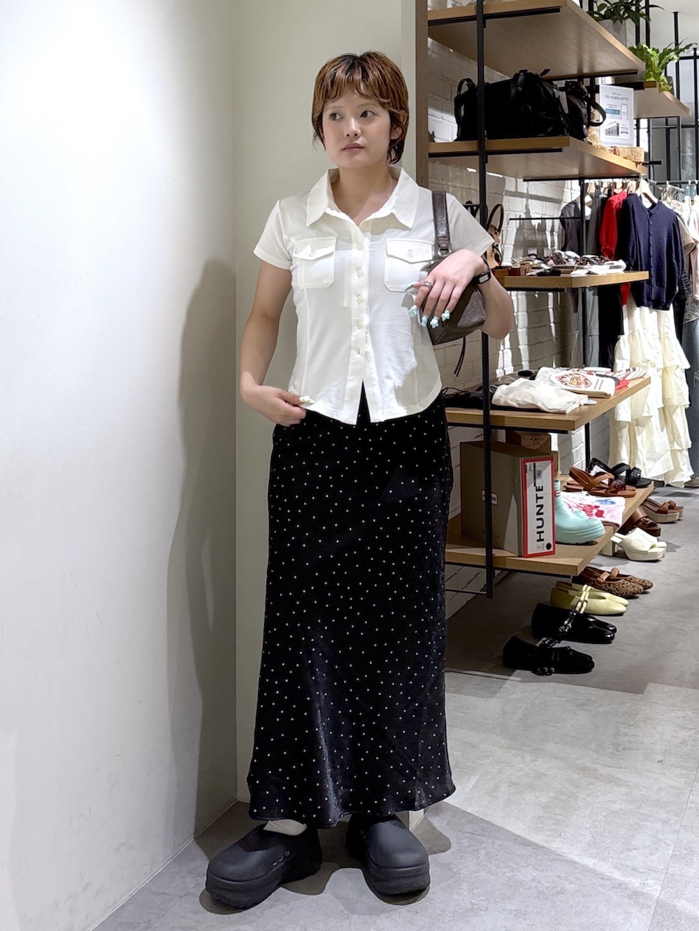 ホワイト系のTシャツ/カットソー、ブラック系のスカート、ブラウン系のショルダーバッグを着用したレディースの夏コーディネートの2枚目の写真