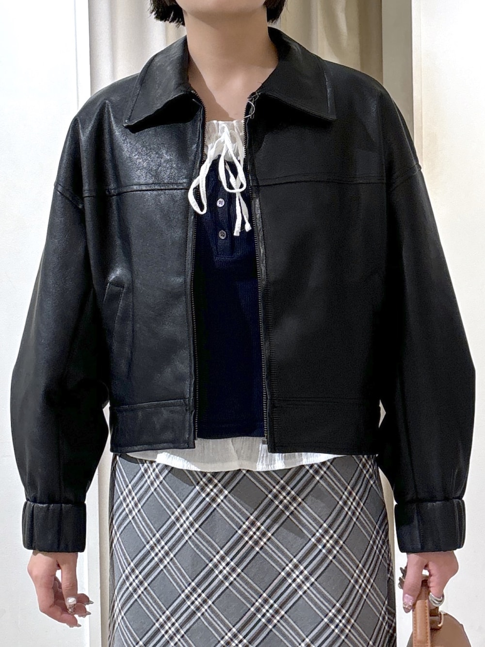 ブラック系のブルゾン、ブルー系のTシャツ/カットソー、ベージュ系のトートバッグを着用したレディースの秋コーディネートの5枚目の写真