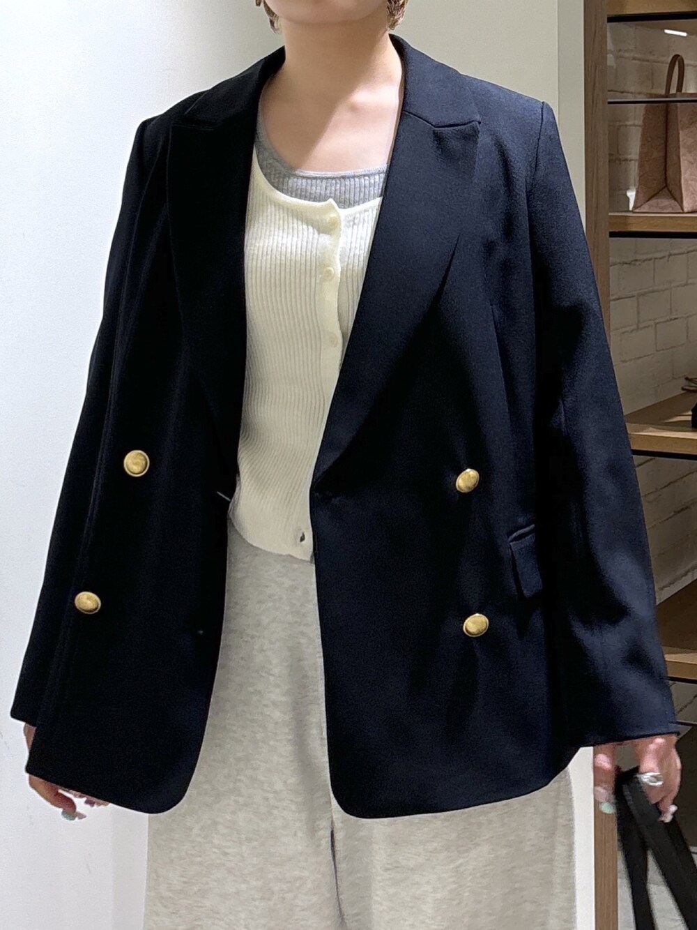 ブルー系のテーラードジャケット、ホワイト系のニット/セーター、ホワイト系のその他パンツを着用したレディースの春コーディネートの5枚目の写真