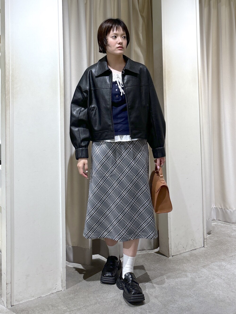 ブラック系のブルゾン、ブルー系のTシャツ/カットソー、ベージュ系のトートバッグを着用したレディースの秋コーディネートの3枚目の写真