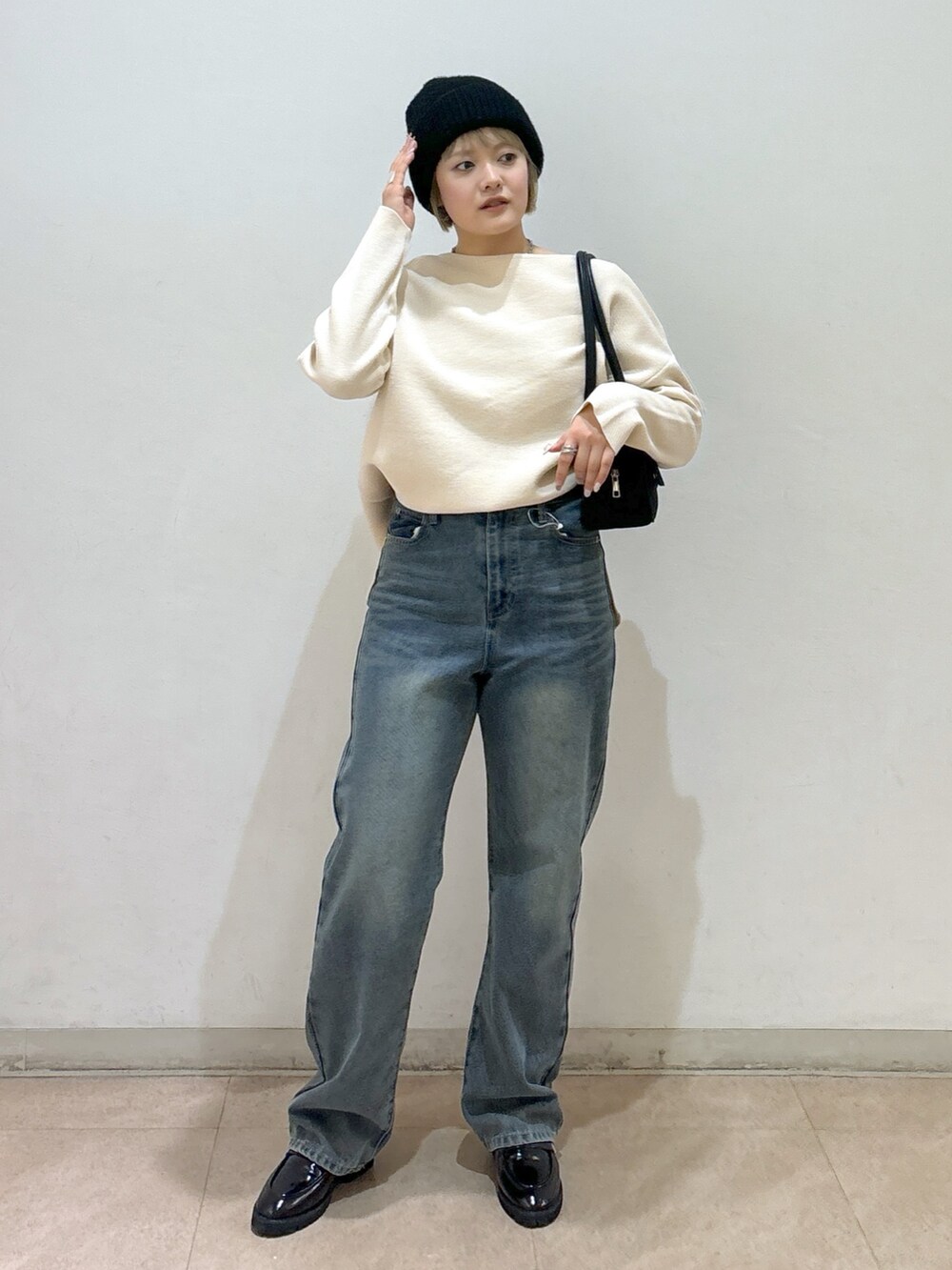 ホワイト系のニット/セーター、ブルー系のデニムパンツ、ブラック系のローファーを着用したレディースの冬コーディネートの2枚目の写真