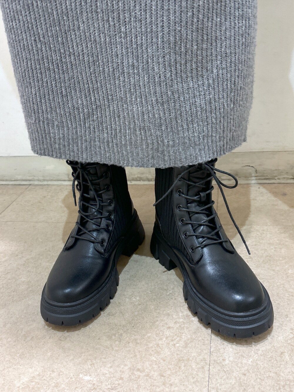 グレー系のワンピース、ホワイト系のダウンジャケット/コート、ブラック系のブーツを着用したレディースの冬コーディネートの10枚目の写真