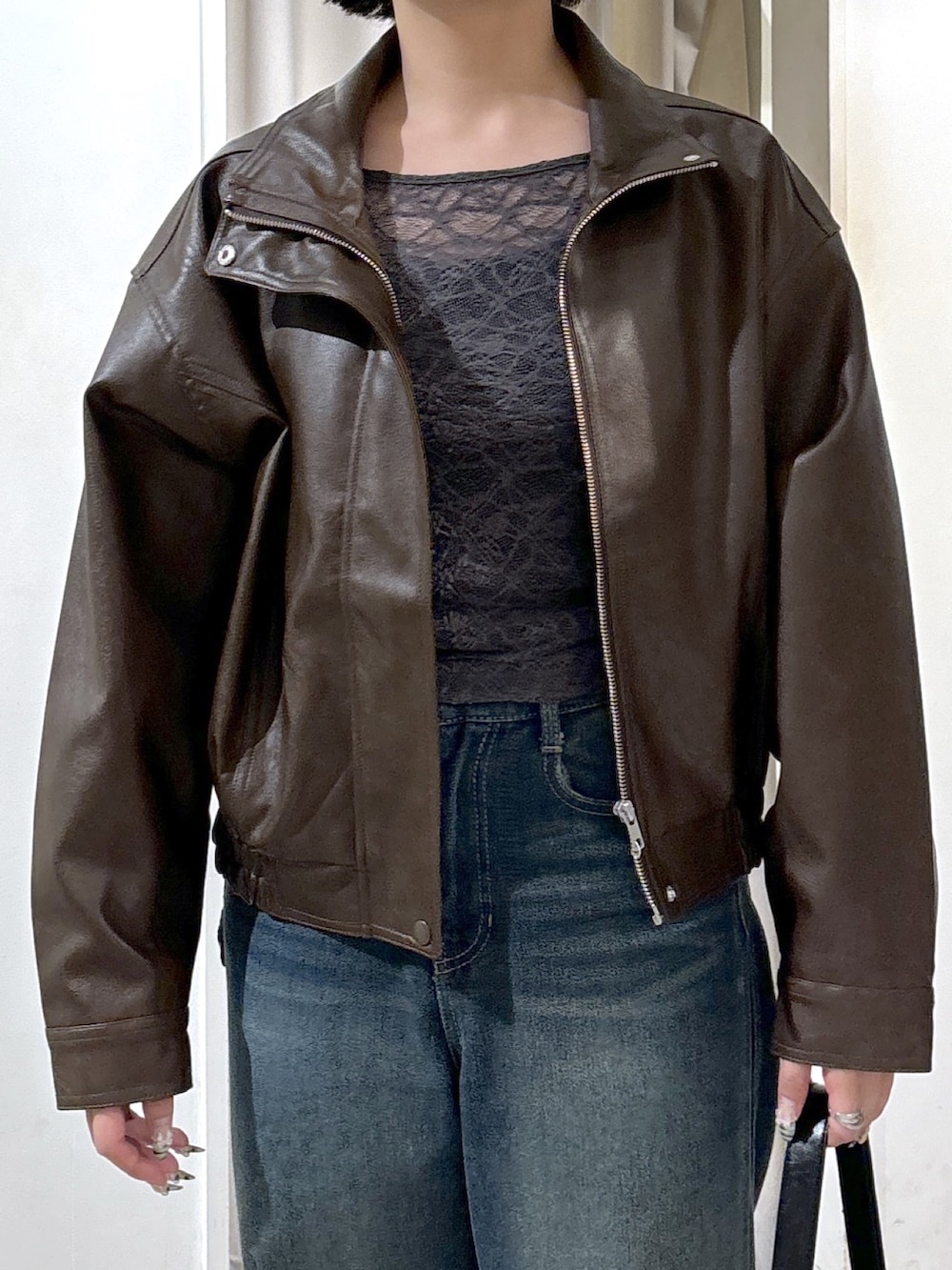 ブラウン系のブルゾン、グレー系のTシャツ/カットソー、ブルー系のデニムパンツを着用したレディースの秋コーディネートの5枚目の写真