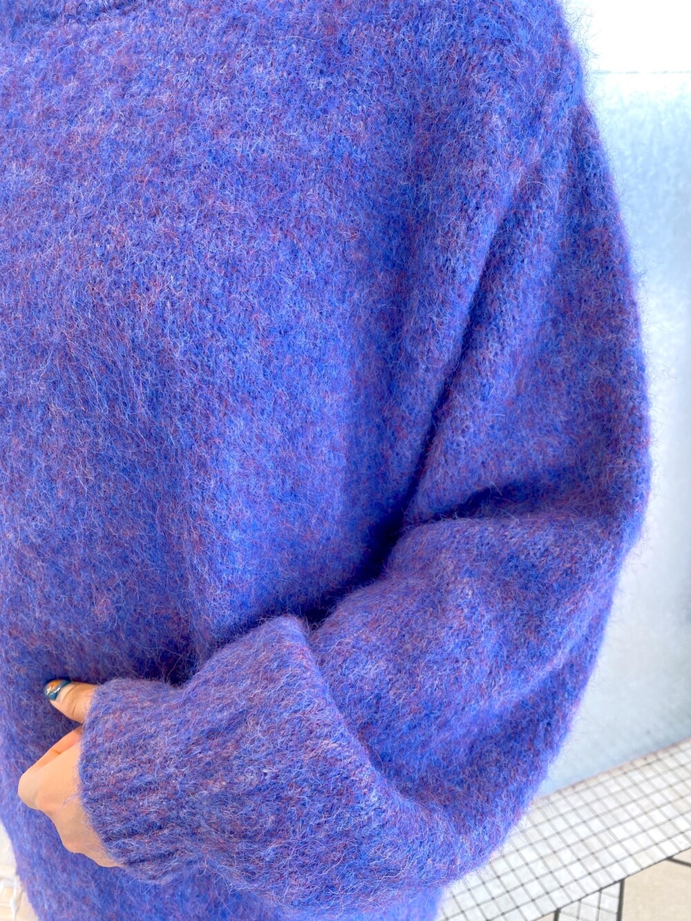 ブルー系のニット/セーター、ホワイト系のショルダーバッグ、ブラック系のデニムパンツを着用したレディースの秋コーディネートの7枚目の写真
