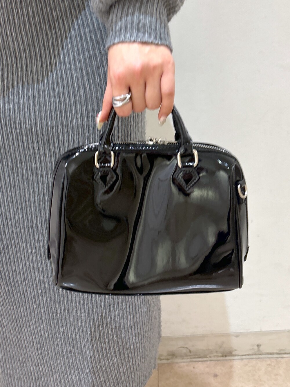 グレー系のワンピース、ホワイト系のダウンジャケット/コート、ブラック系のブーツを着用したレディースの冬コーディネートの9枚目の写真