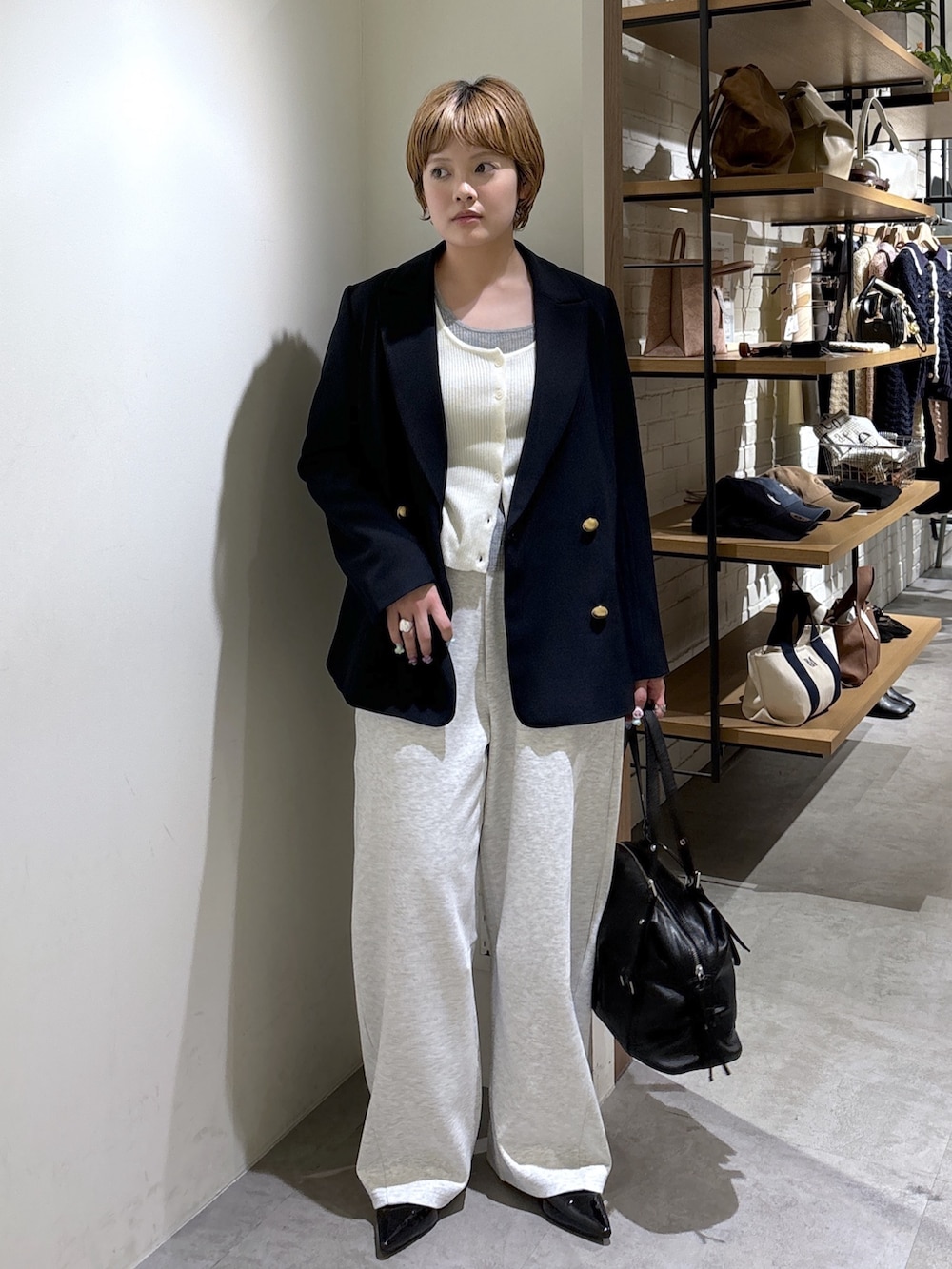 ブルー系のテーラードジャケット、ホワイト系のニット/セーター、ホワイト系のその他パンツを着用したレディースの春コーディネートの2枚目の写真