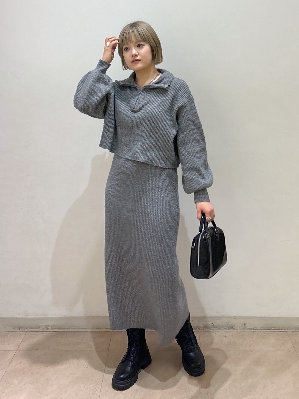 グレー系のワンピース、ホワイト系のダウンジャケット/コート、ブラック系のブーツを着用したレディースの冬コーディネートの7枚目の写真