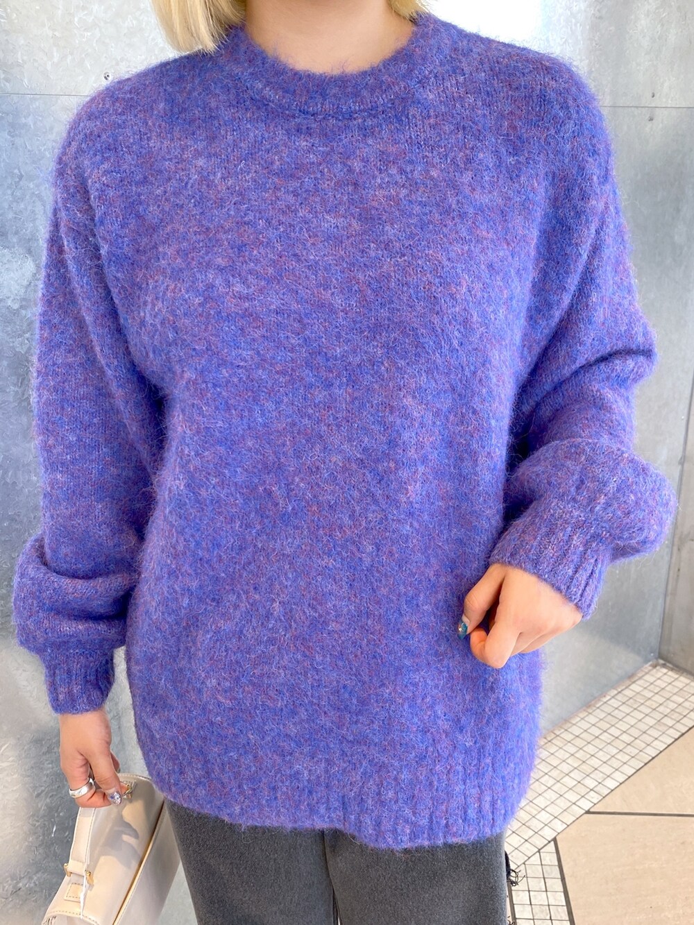 ブルー系のニット/セーター、ホワイト系のショルダーバッグ、ブラック系のデニムパンツを着用したレディースの秋コーディネートの6枚目の写真