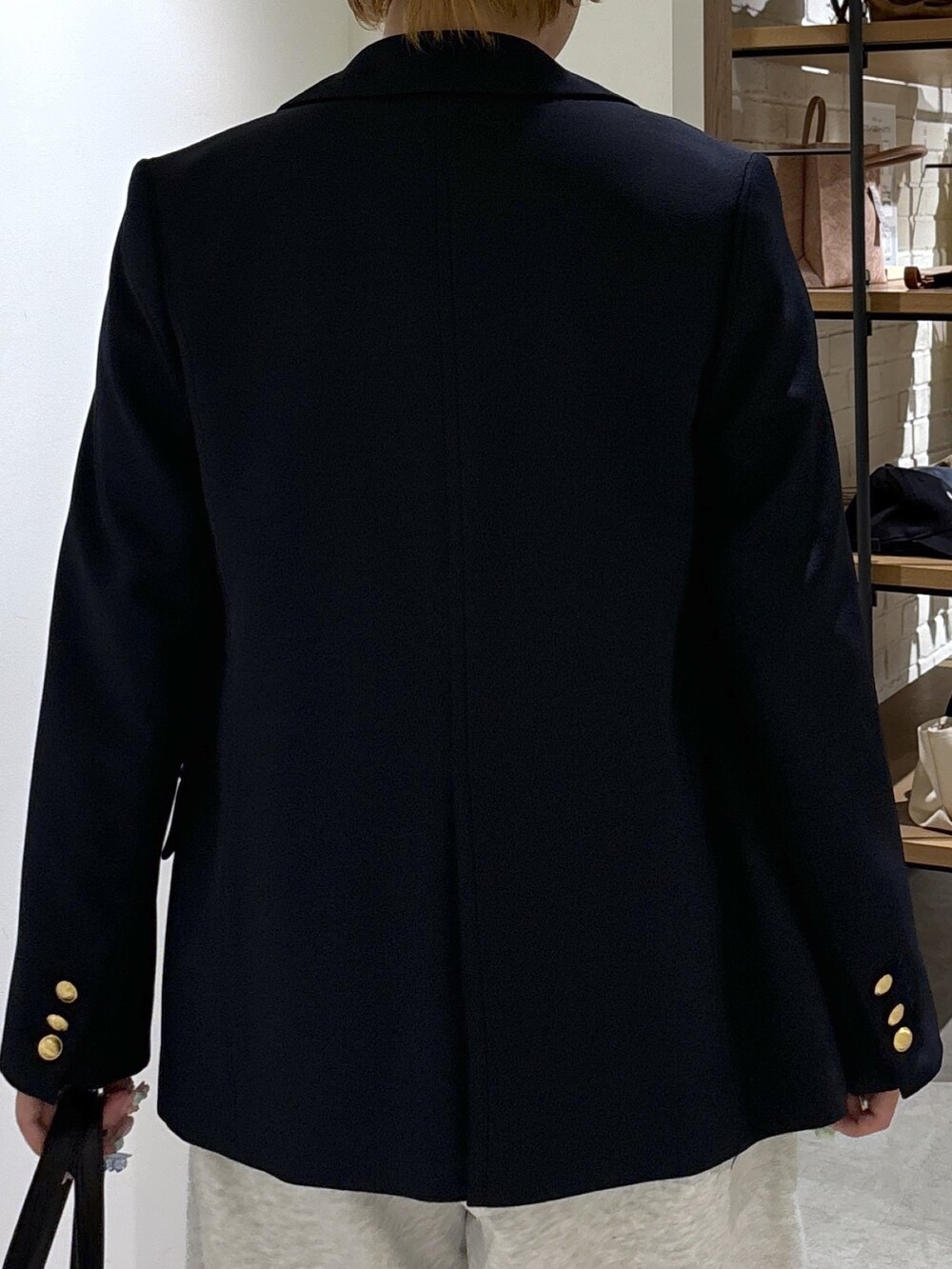 ブルー系のテーラードジャケット、ホワイト系のニット/セーター、ホワイト系のその他パンツを着用したレディースの春コーディネートの6枚目の写真