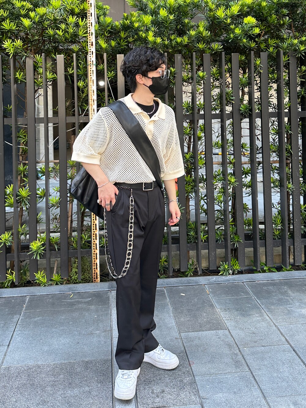 ベージュ系のポロシャツ、ブラック系のショルダーバッグ、ブラック系のスラックスを着用したメンズの夏コーディネートの4枚目の写真