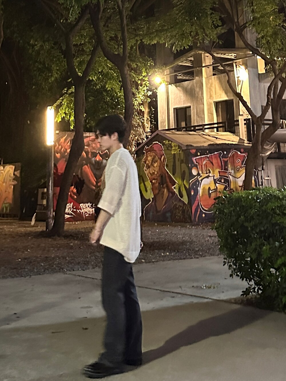 ブラック系のデニムパンツ、ベージュ系のポロシャツ、ブラック系のシューズを着用したメンズの夏コーディネートの3枚目の写真