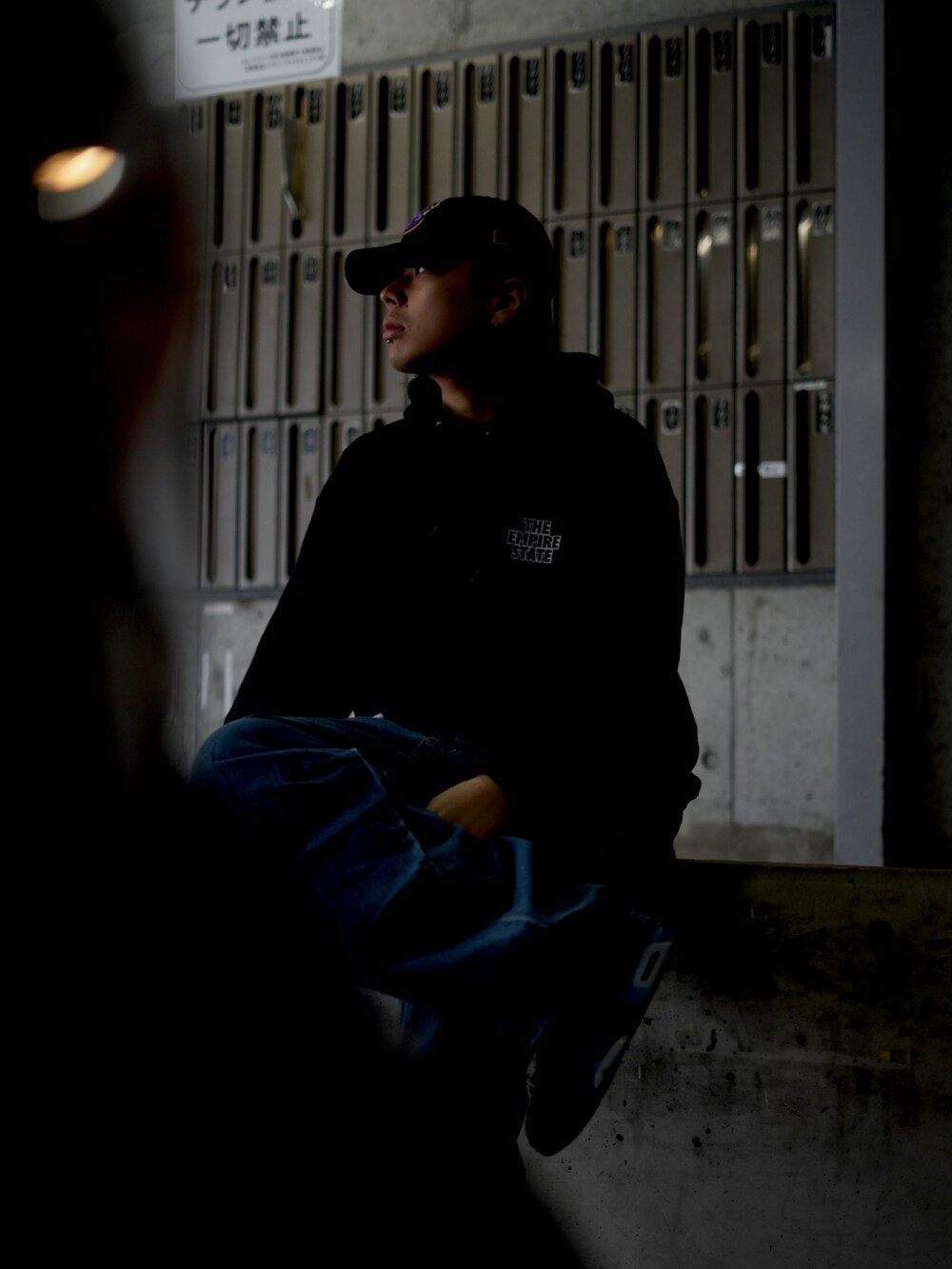 ブラック系のパーカー、ブルー系のデニムパンツを着用したメンズの秋コーディネートの2枚目の写真