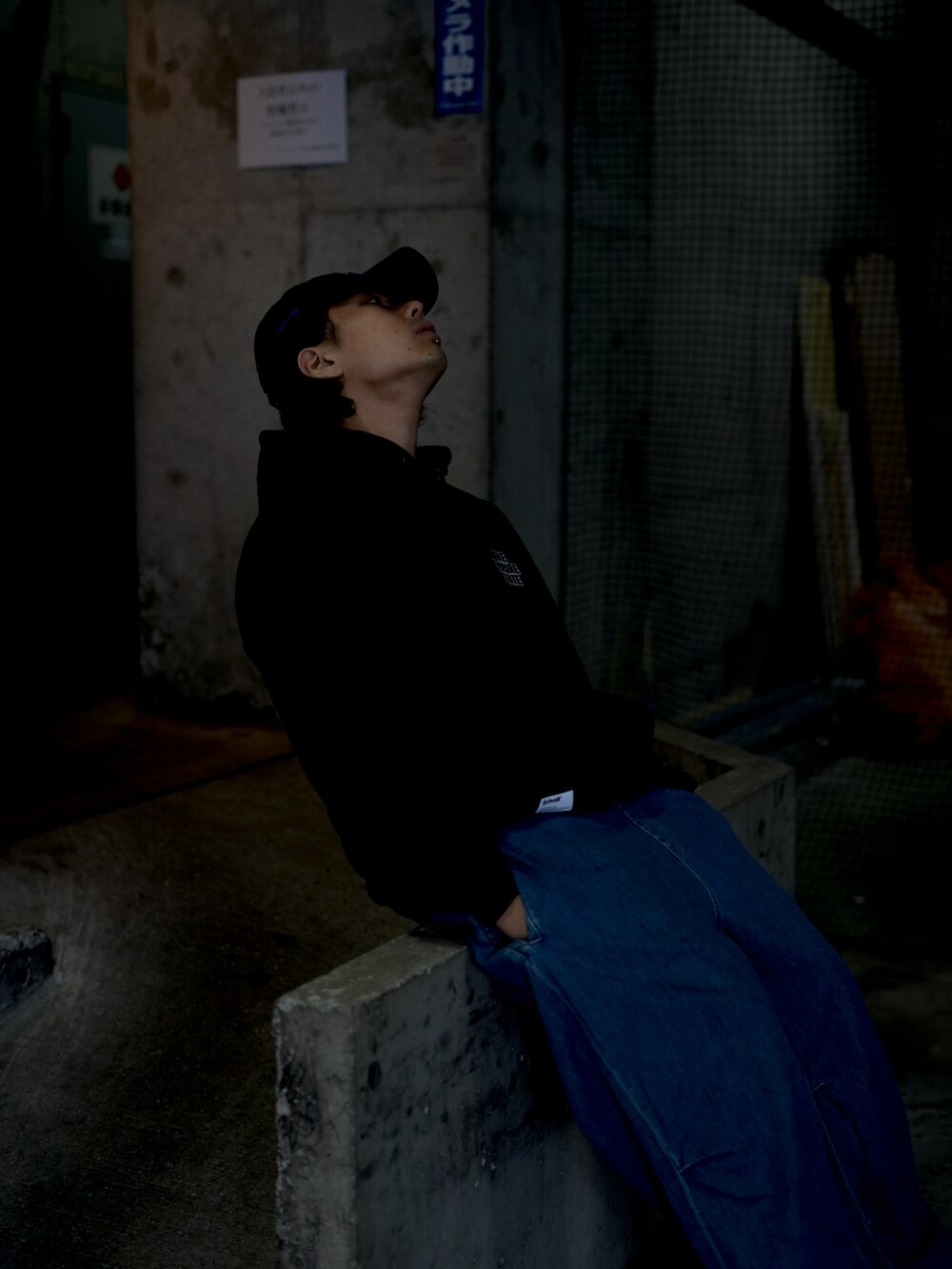 ブラック系のパーカー、ブルー系のデニムパンツを着用したメンズの秋コーディネートの3枚目の写真