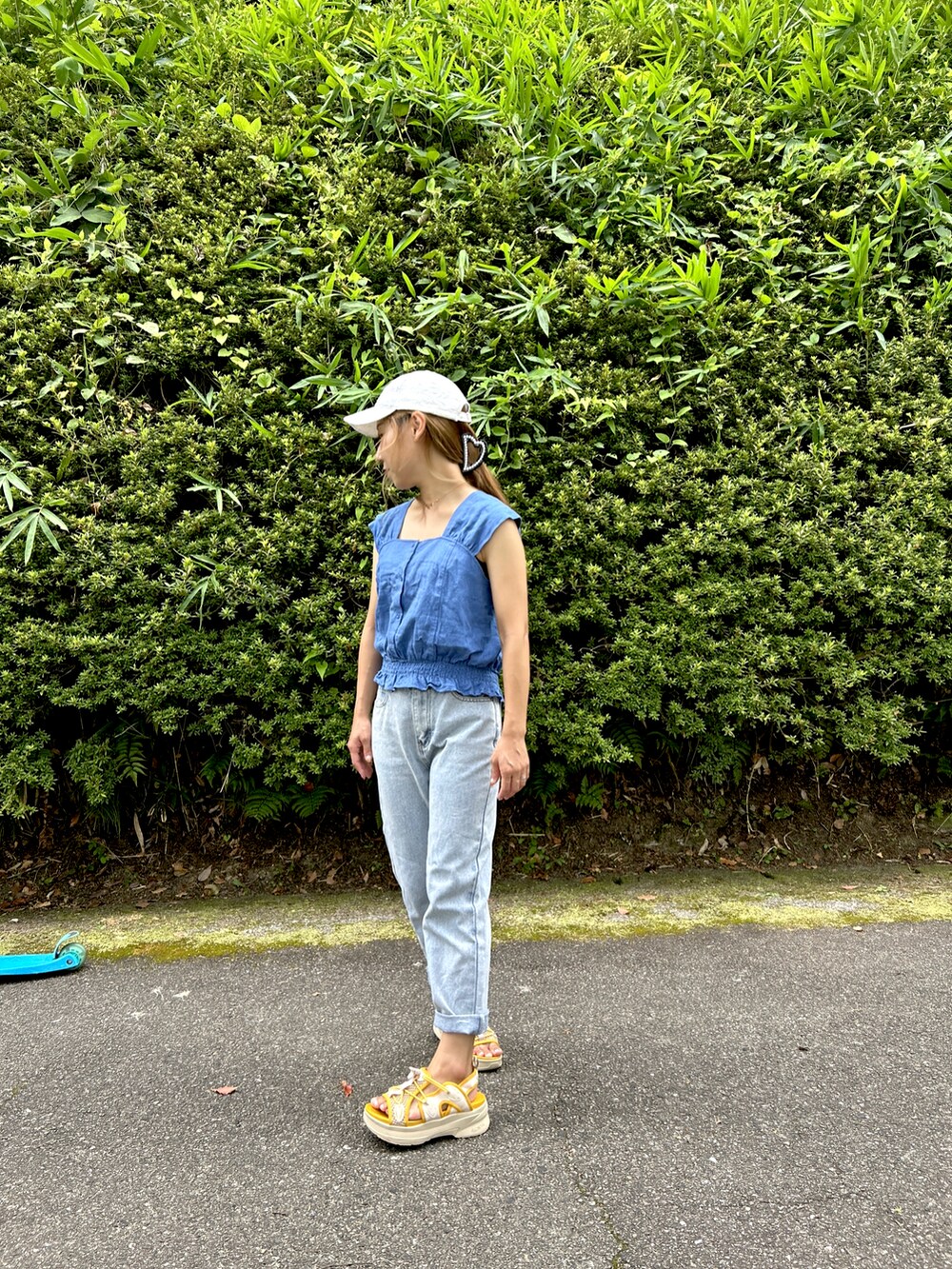 ブルー系のシャツ/ブラウス、イエロー系のサンダル、グリーン系のTシャツ/カットソーを着用したレディースの夏コーディネートの2枚目の写真